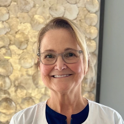 Dental Hygienist Cindy Smiling In Front Of Art Piece