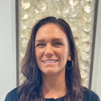 Dental Assistant Erin Smiling In Front Of Art Piece