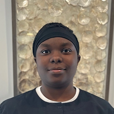 Dental Assistant Jamie Smiling In Front Of Art Piece